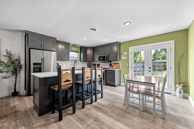 312 NW J St, Bentonville, AR 72712 - kitchen with appliances with stainless steel finishes, baseboards, french doors, light wood finished floors, and recessed lighting