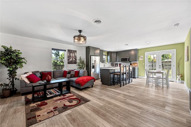312 NW J St, Bentonville, AR 72712 - living room featuring french doors, light wood-style floors, and baseboards