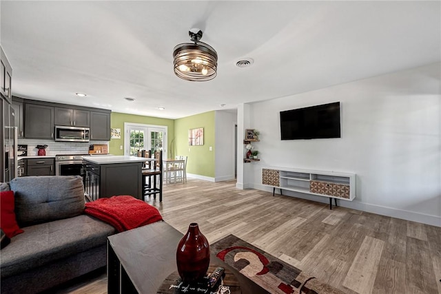 312 NW J St, Bentonville, AR 72712 - living area featuring baseboards, french doors, light wood finished floors, and recessed lighting