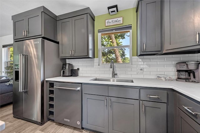 312 NW J St, Bentonville, AR 72712 - kitchen with a sink, stainless steel appliances, decorative backsplash, and light countertops