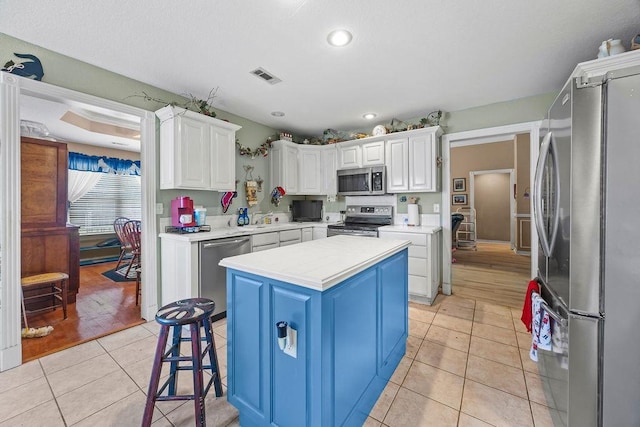 2977 Quartz Dr, Fayetteville, AR 72704 - kitchen with stainless steel appliances, light countertops, light tile patterned floors, white cabinets, and recessed lighting