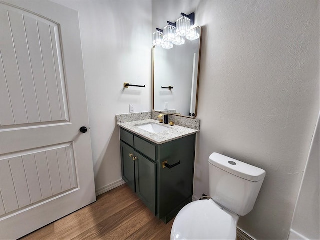 1115 N Leverett Ave Unit 102, Fayetteville, AR 72703 - bathroom featuring vanity, toilet, wood finished floors, and a chandelier