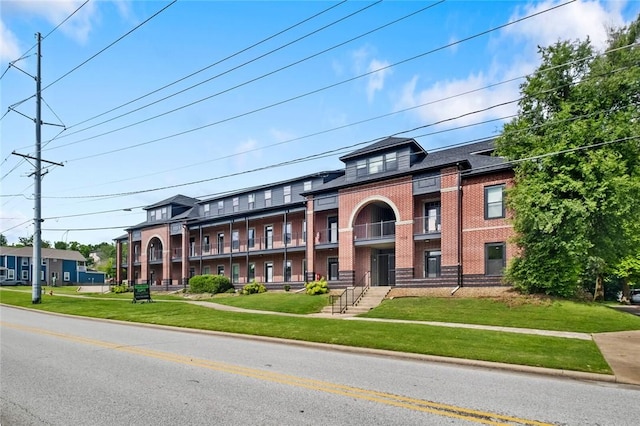1115 N Leverett Ave Unit 102, Fayetteville, AR 72703 - townhome / multi-family property featuring a balcony, brick siding, and a front lawn