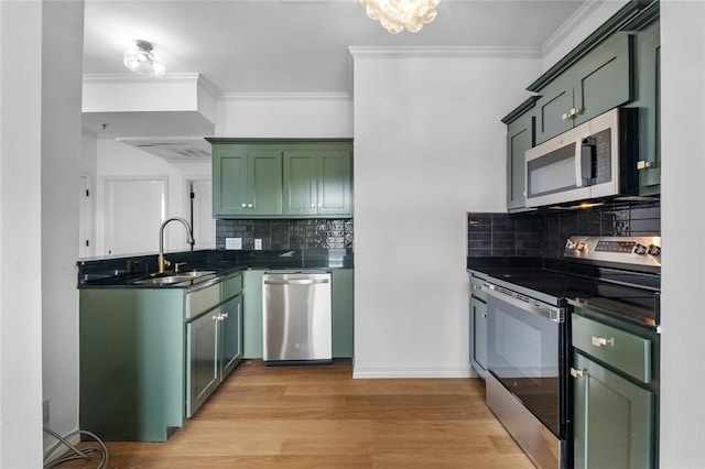 1115 N Leverett Ave Unit 102, Fayetteville, AR 72703 - kitchen with appliances with stainless steel finishes, green cabinetry, a sink, dark countertops, and ornamental molding