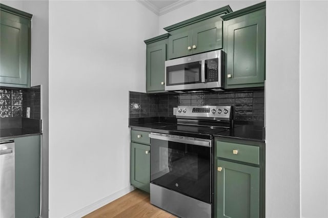 1115 N Leverett Ave Unit 102, Fayetteville, AR 72703 - kitchen featuring green cabinetry, stainless steel appliances, dark countertops, crown molding, and tasteful backsplash
