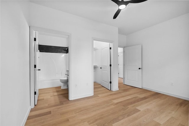 1115 N Leverett Ave Unit 102, Fayetteville, AR 72703 - unfurnished bedroom featuring light wood-style floors, a spacious closet, and baseboards