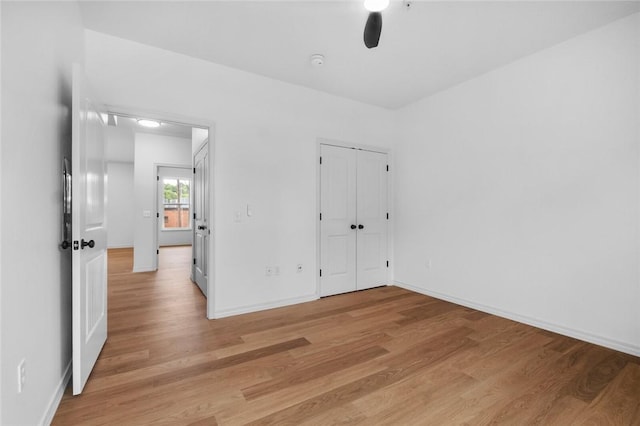1115 N Leverett Ave Unit 102, Fayetteville, AR 72703 - unfurnished bedroom with light wood-style flooring, baseboards, a ceiling fan, and a closet