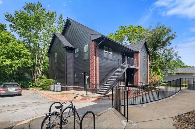 1115 N Leverett Ave Unit 102, Fayetteville, AR 72703 - view of front of home featuring stairway, central AC unit, and a shingled roof