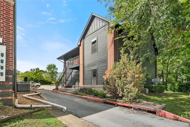 1115 N Leverett Ave Unit 102, Fayetteville, AR 72703 - view of side of home featuring board and batten siding, stairway, and central air condition unit