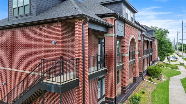 1115 N Leverett Ave Unit 102, Fayetteville, AR 72703 - view of home's exterior with brick siding, roof with shingles, and a balcony