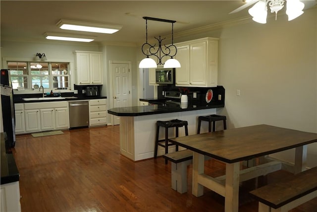 2655 S Elmira Ave, Russellville, AR 72802 - kitchen with stainless steel appliances, a sink, a peninsula, dark countertops, and white cabinets