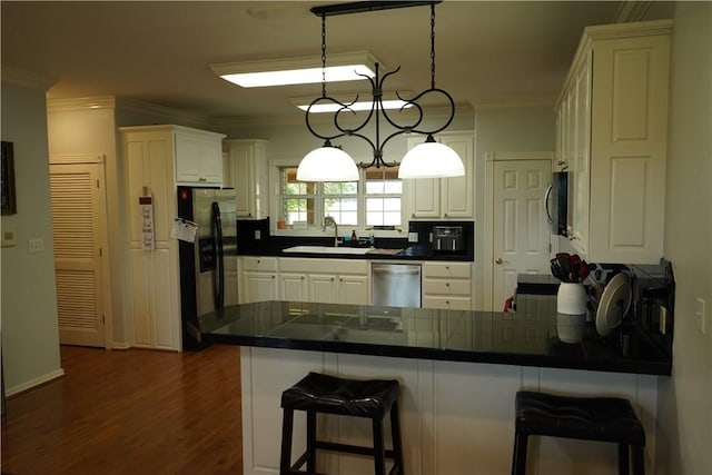2655 S Elmira Ave, Russellville, AR 72802 - kitchen with stainless steel appliances, a sink, a peninsula, ornamental molding, and a kitchen bar