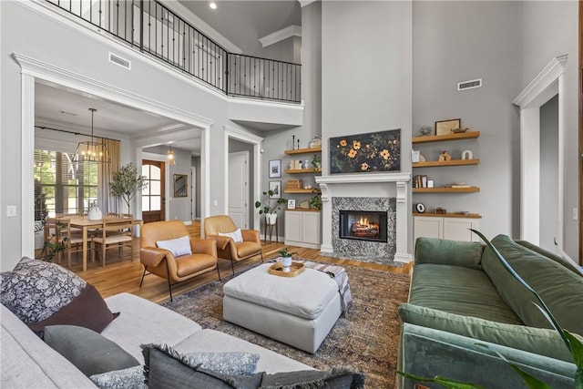 13 Dawn Hills Dr, Bentonville, AR 72712 - living area featuring a towering ceiling, wood finished floors, a chandelier, and a tile fireplace