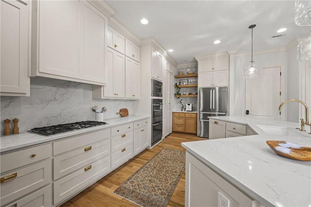 13 Dawn Hills Dr, Bentonville, AR 72712 - kitchen featuring a sink, appliances with stainless steel finishes, open shelves, decorative backsplash, and light wood-style floors