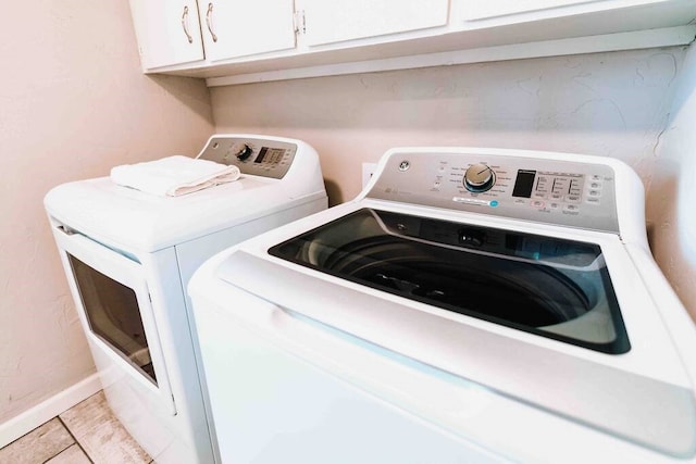 208 NW L St, Bentonville, AR 72712 - washroom featuring washing machine and dryer, cabinet space, and baseboards