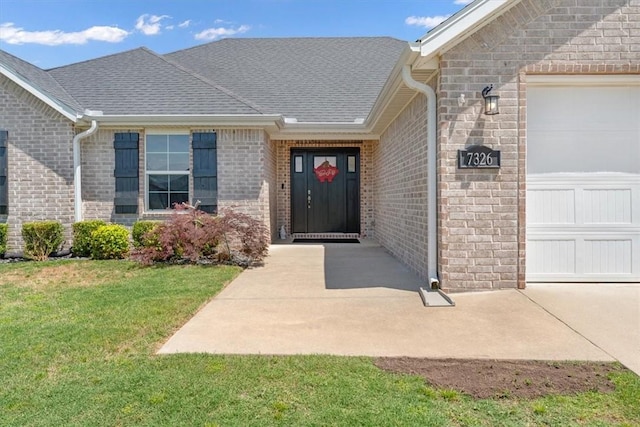 7326 Drury Ave, Springdale, AR 72762 - property entrance featuring an attached garage, brick siding, and a yard