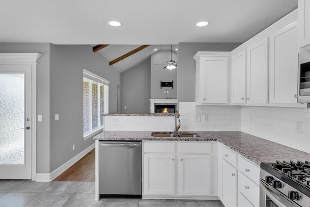 7326 Drury Ave, Springdale, AR 72762 - kitchen featuring stainless steel dishwasher, a sink, a ceiling fan, tasteful backsplash, and dark stone countertops