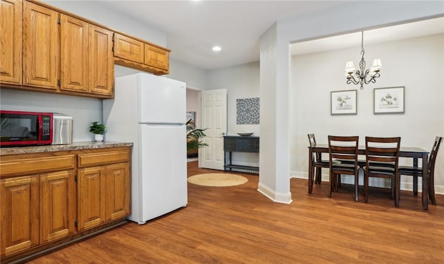 9193 Grimes Dr, Rogers, AR 72756 - kitchen with freestanding refrigerator, light wood-type flooring, recessed lighting, a chandelier, and baseboards