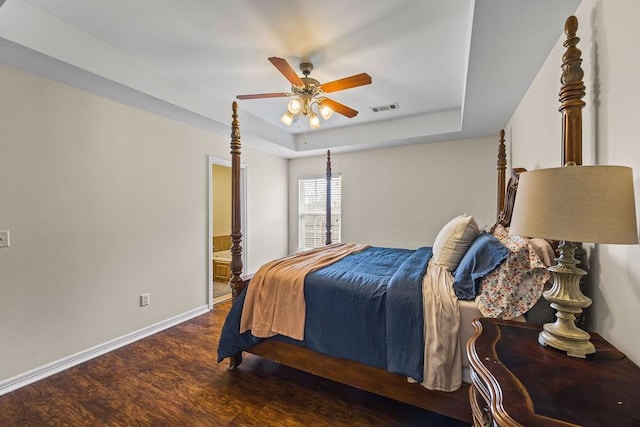 340 Mckissic Spring Rd, Centerton, AR 72719 - bedroom with a raised ceiling, wood finished floors, baseboards, connected bathroom, and ceiling fan