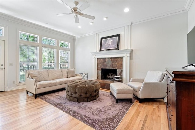 1325 Avery Pl, Siloam Springs, AR 72761 - living room with crown molding, light wood-style floors, ceiling fan, a fireplace with raised hearth, and recessed lighting