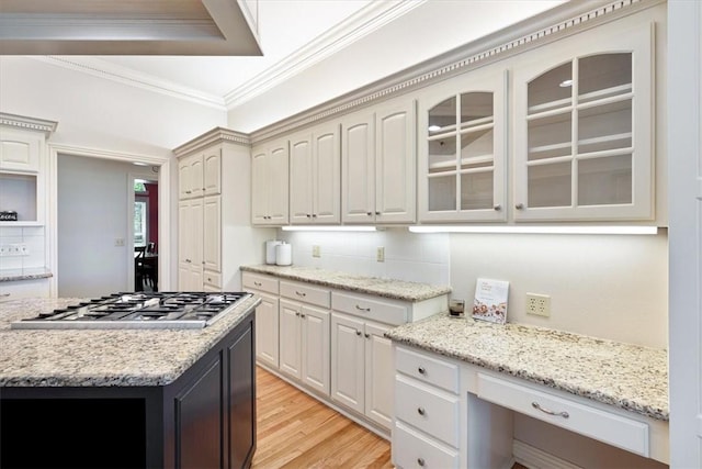 1325 Avery Pl, Siloam Springs, AR 72761 - kitchen with stainless steel gas stovetop, crown molding, glass insert cabinets, light wood finished floors, and light stone countertops