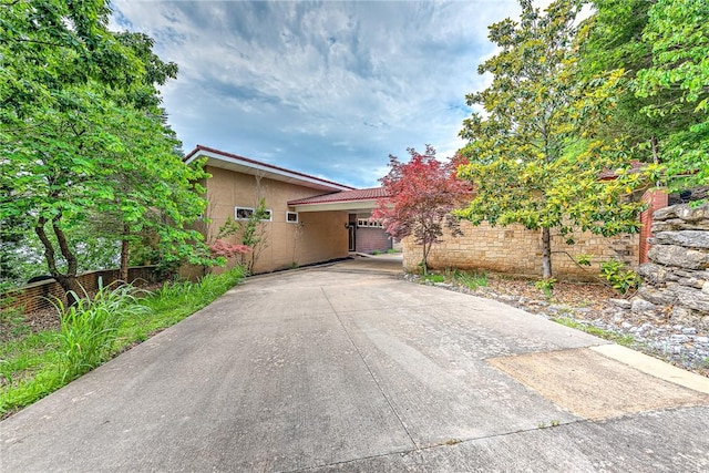 289 County Road 1521, Eureka Springs, AR 72632 - view of front of house with stucco siding, driveway, and a tile roof