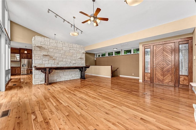 289 County Road 1521, Eureka Springs, AR 72632 - unfurnished living room with light wood-type flooring, lofted ceiling, a ceiling fan, rail lighting, and baseboards