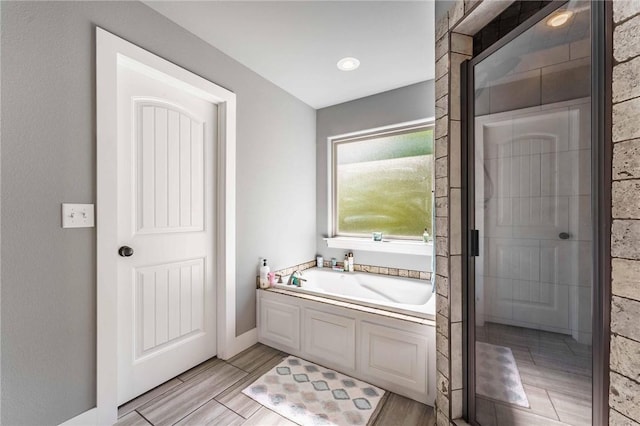 960 Glass St, Cave Springs, AR 72718 - bathroom featuring a garden tub, baseboards, and wood finished floors