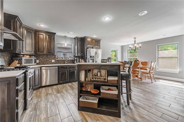960 Glass St, Cave Springs, AR 72718 - kitchen featuring stainless steel appliances, open shelves, dark brown cabinets, a chandelier, and recessed lighting