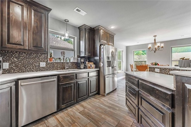 960 Glass St, Cave Springs, AR 72718 - kitchen featuring appliances with stainless steel finishes, a sink, a chandelier, dark brown cabinetry, and light countertops