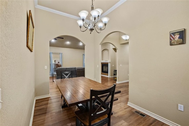 8 Allonby Cir, Bella Vista, AR 72714 - dining room featuring arched walkways, crown molding, a chandelier, baseboards, and wood finished floors