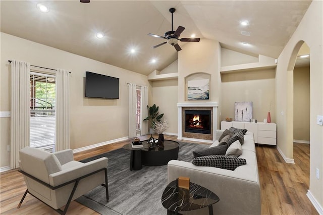 8 Allonby Cir, Bella Vista, AR 72714 - living area with arched walkways, ceiling fan, wood finished floors, lofted ceiling, and a lit fireplace