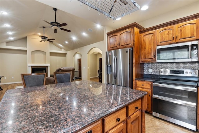 8 Allonby Cir, Bella Vista, AR 72714 - kitchen featuring stainless steel appliances, a ceiling fan, arched walkways, backsplash, and lofted ceiling