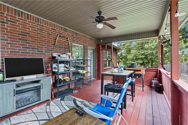 8 Allonby Cir, Bella Vista, AR 72714 - wooden deck with outdoor dining area, ceiling fan, and an outdoor kitchen