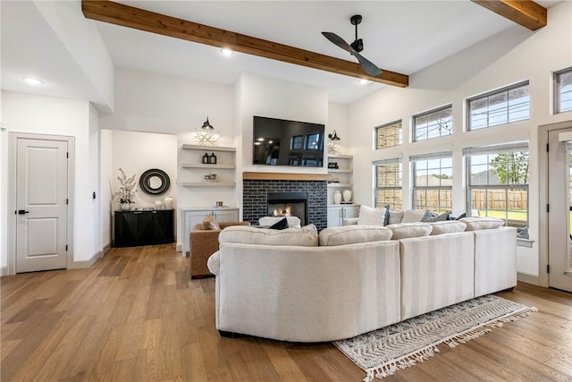 839 Saffron Ave, Tontitown, AR 72762 - living area with ceiling fan, beamed ceiling, a tiled fireplace, healthy amount of natural light, and light wood finished floors