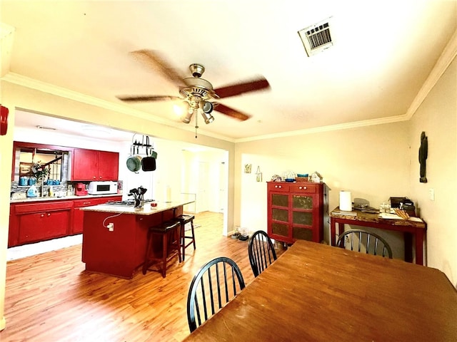 12088 State Highway 28, Dardanelle, AR 72834 - dining space with light wood-style floors, crown molding, and ceiling fan