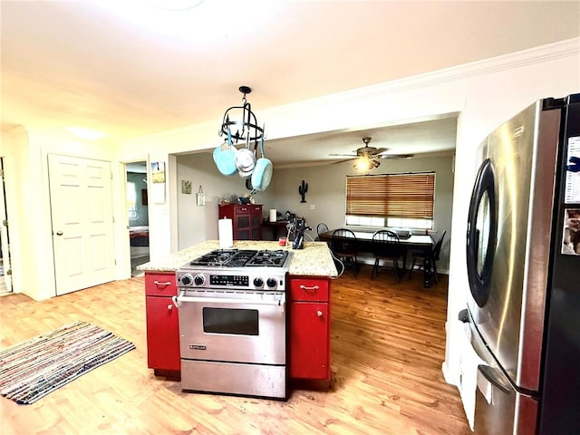 12088 State Highway 28, Dardanelle, AR 72834 - kitchen with stainless steel appliances, red cabinets, ornamental molding, light wood-type flooring, and light countertops