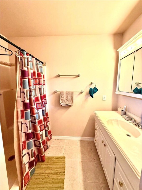 12088 State Highway 28, Dardanelle, AR 72834 - bathroom featuring vanity, a shower with curtain, baseboards, and tile patterned flooring