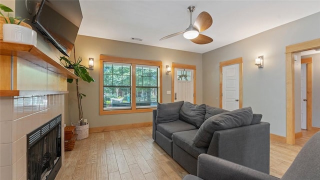 1806 Best Friend Ln, Fayetteville, AR 72704 - living area with ceiling fan, light wood finished floors, a tiled fireplace, and baseboards