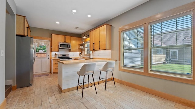1806 Best Friend Ln, Fayetteville, AR 72704 - kitchen featuring stainless steel appliances, a peninsula, baseboards, plenty of natural light, and recessed lighting