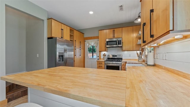 1806 Best Friend Ln, Fayetteville, AR 72704 - kitchen featuring appliances with stainless steel finishes, a peninsula, a sink, wood counters, and recessed lighting