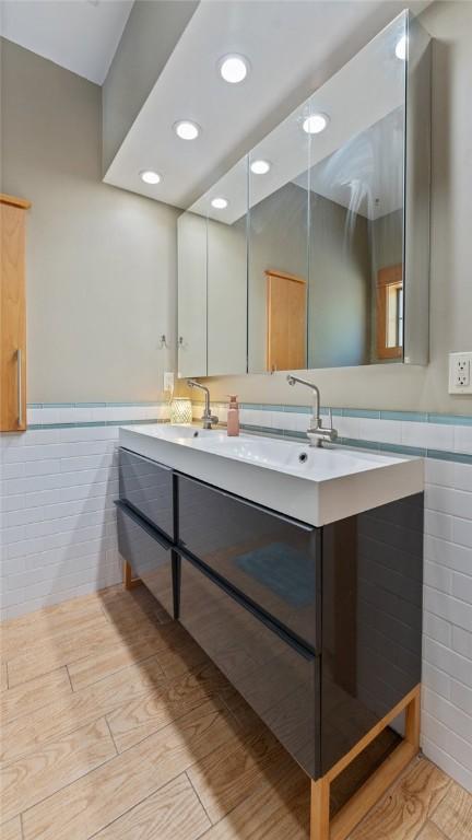 1806 Best Friend Ln, Fayetteville, AR 72704 - full bathroom with tile walls, double vanity, wainscoting, recessed lighting, and wood finished floors