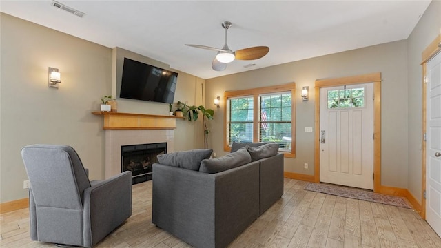 1806 Best Friend Ln, Fayetteville, AR 72704 - living room with a tiled fireplace, ceiling fan, light wood-type flooring, and baseboards