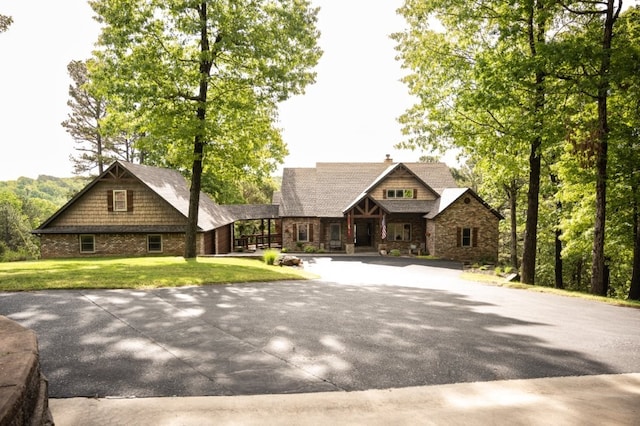 8295 Ridgecrest Ln, Rogers, AR 72756 - view of front facade with stone siding, a front lawn, driveway, a porch, and brick siding