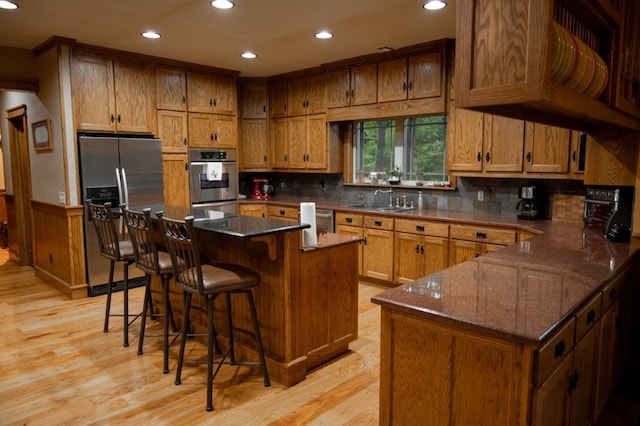 8295 Ridgecrest Ln, Rogers, AR 72756 - kitchen featuring stainless steel appliances, a sink, recessed lighting, light wood finished floors, and brown cabinetry