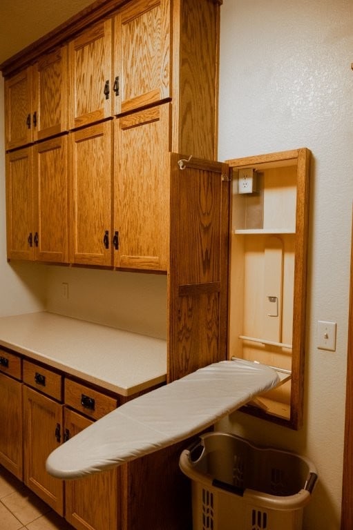 8295 Ridgecrest Ln, Rogers, AR 72756 - kitchen with brown cabinets, light tile patterned floors, and light countertops