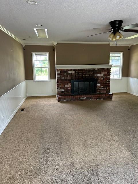 1103 NW 10th St, Bentonville, AR 72712 - unfurnished living room featuring a textured ceiling, crown molding, a wainscoted wall, carpet floors, and a ceiling fan