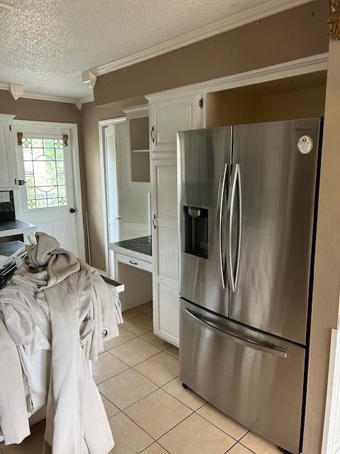 1103 NW 10th St, Bentonville, AR 72712 - kitchen featuring stainless steel refrigerator with ice dispenser, crown molding, a textured ceiling, white cabinets, and light tile patterned flooring