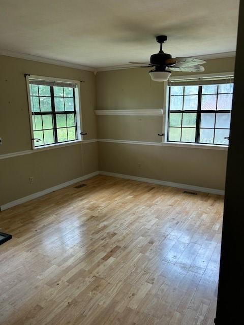 1103 NW 10th St, Bentonville, AR 72712 - empty room with ornamental molding, plenty of natural light, a ceiling fan, wood finished floors, and baseboards