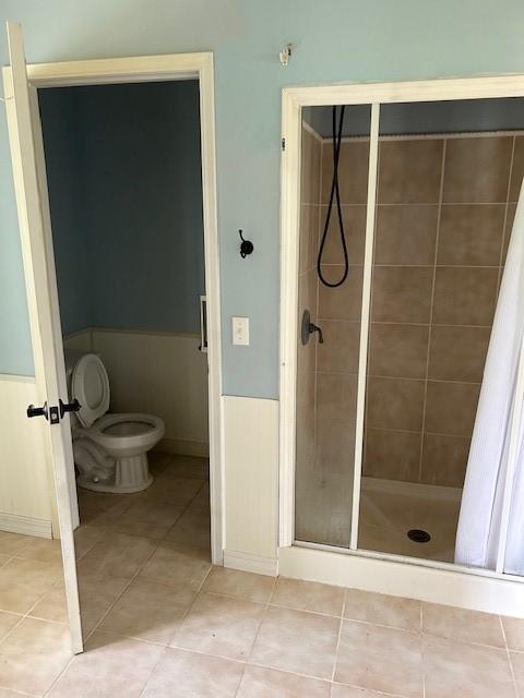 1103 NW 10th St, Bentonville, AR 72712 - bathroom featuring toilet, a stall shower, and tile patterned flooring